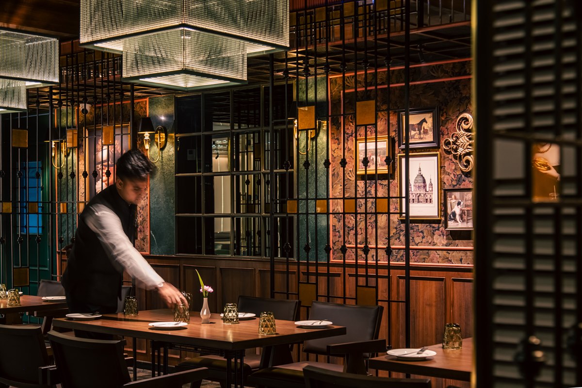 Restaurant dining room with a team member preparing a table