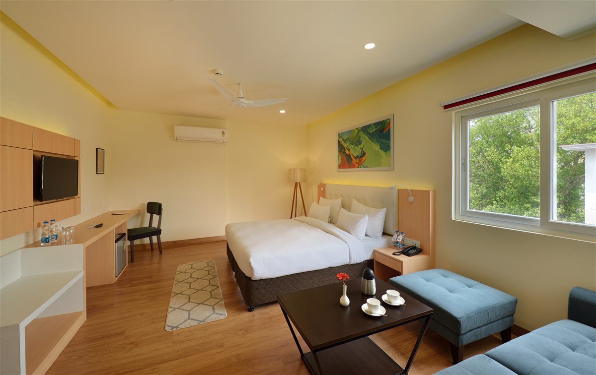 Bright Luxury Club room with a double bed, seating and large windows